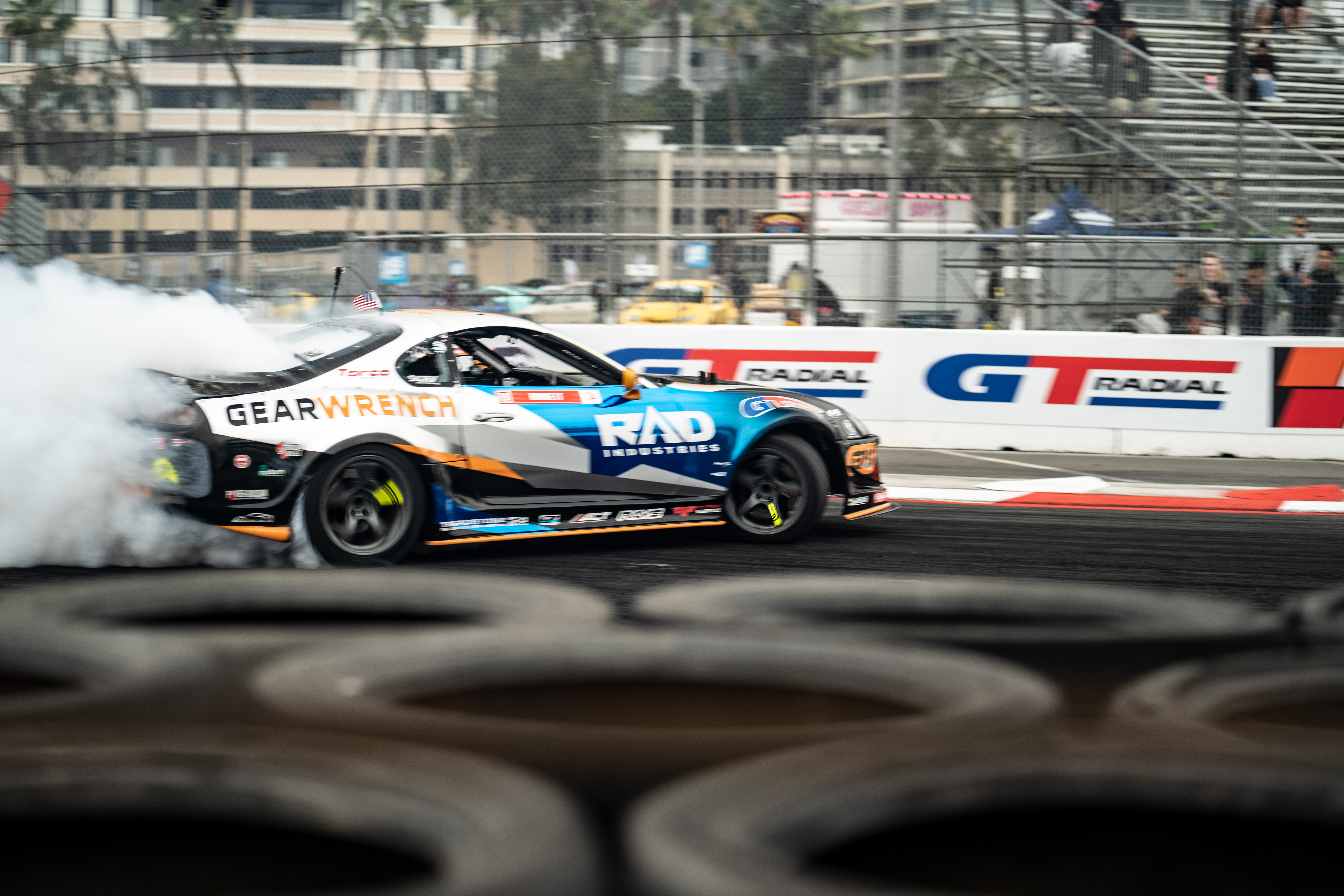 Black track car photographed in motion on a race circuit